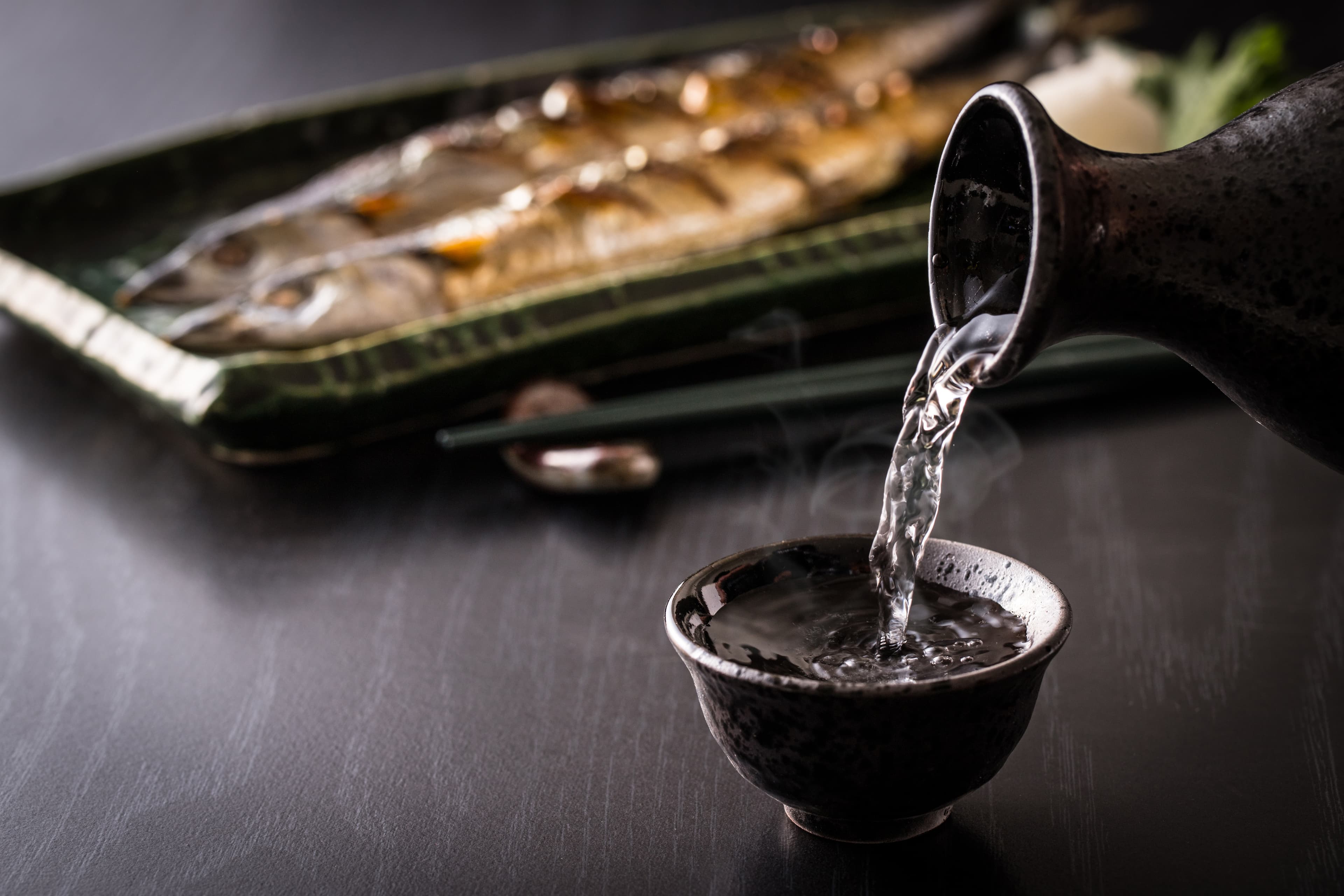 Sake being poured into ochoko cup